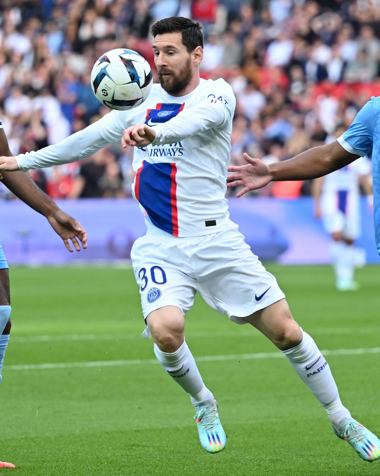 Lionel Messi (PSG) contrôle le ballon entre deux Troyens.